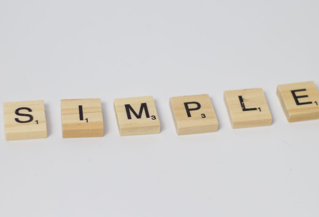 Scrabble-Steine, die das Wort SIMPLE ergeben